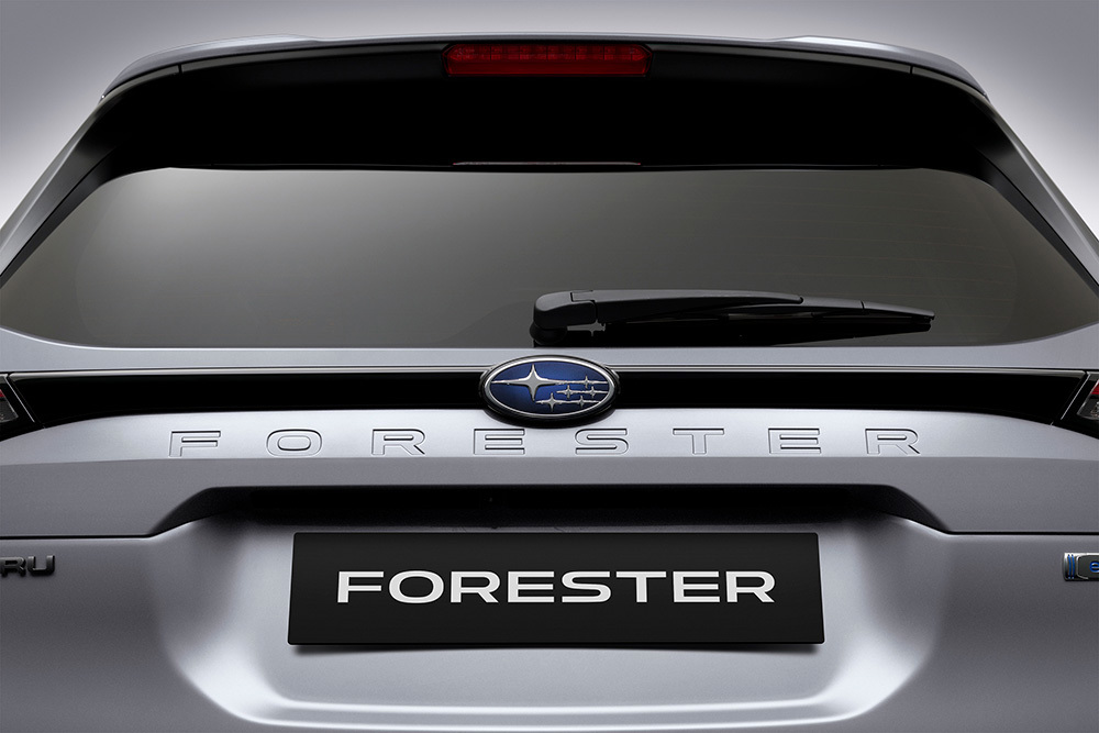 Lähivõte Subaru embleemist ja pagasiluugile graveeritud Forester-logost.