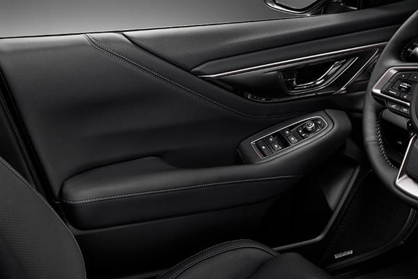 Subaru juhiukse sisekülg koos käetoe ning elektriakende ja peegli seadistamise nuppudega.